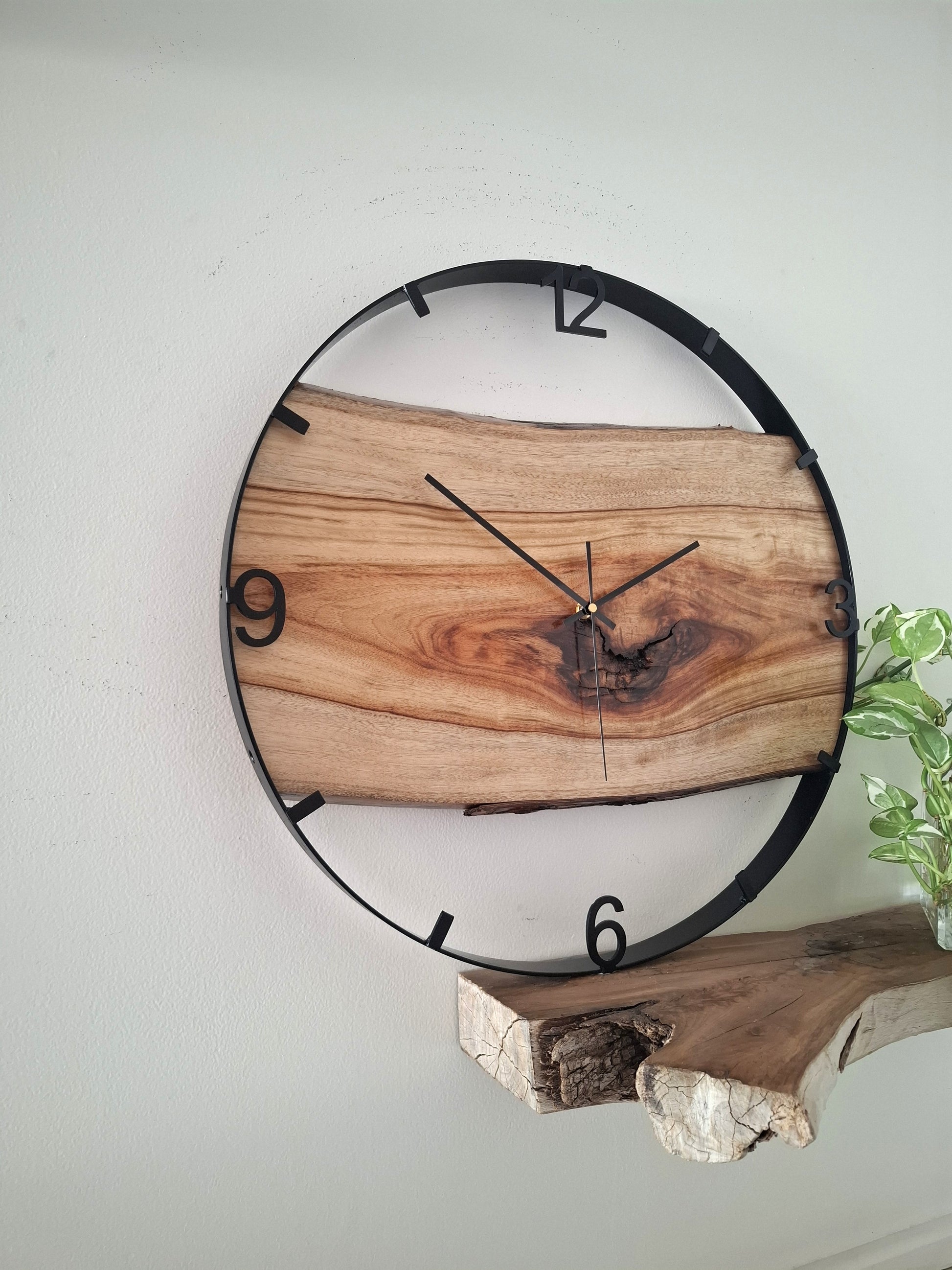 Wooden wall clock with natural finish on a white wall