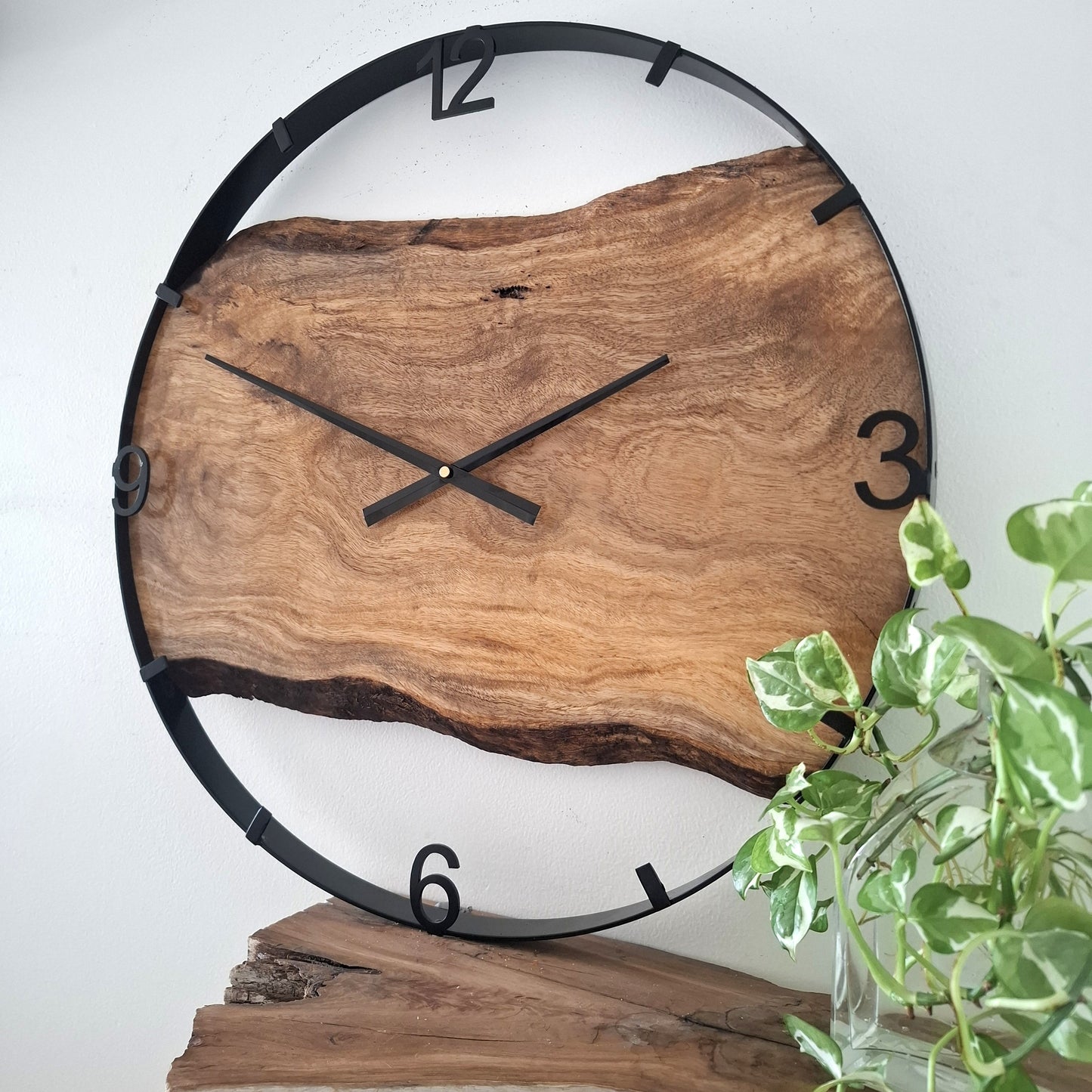 Wooden wall clock with black frame on a white background