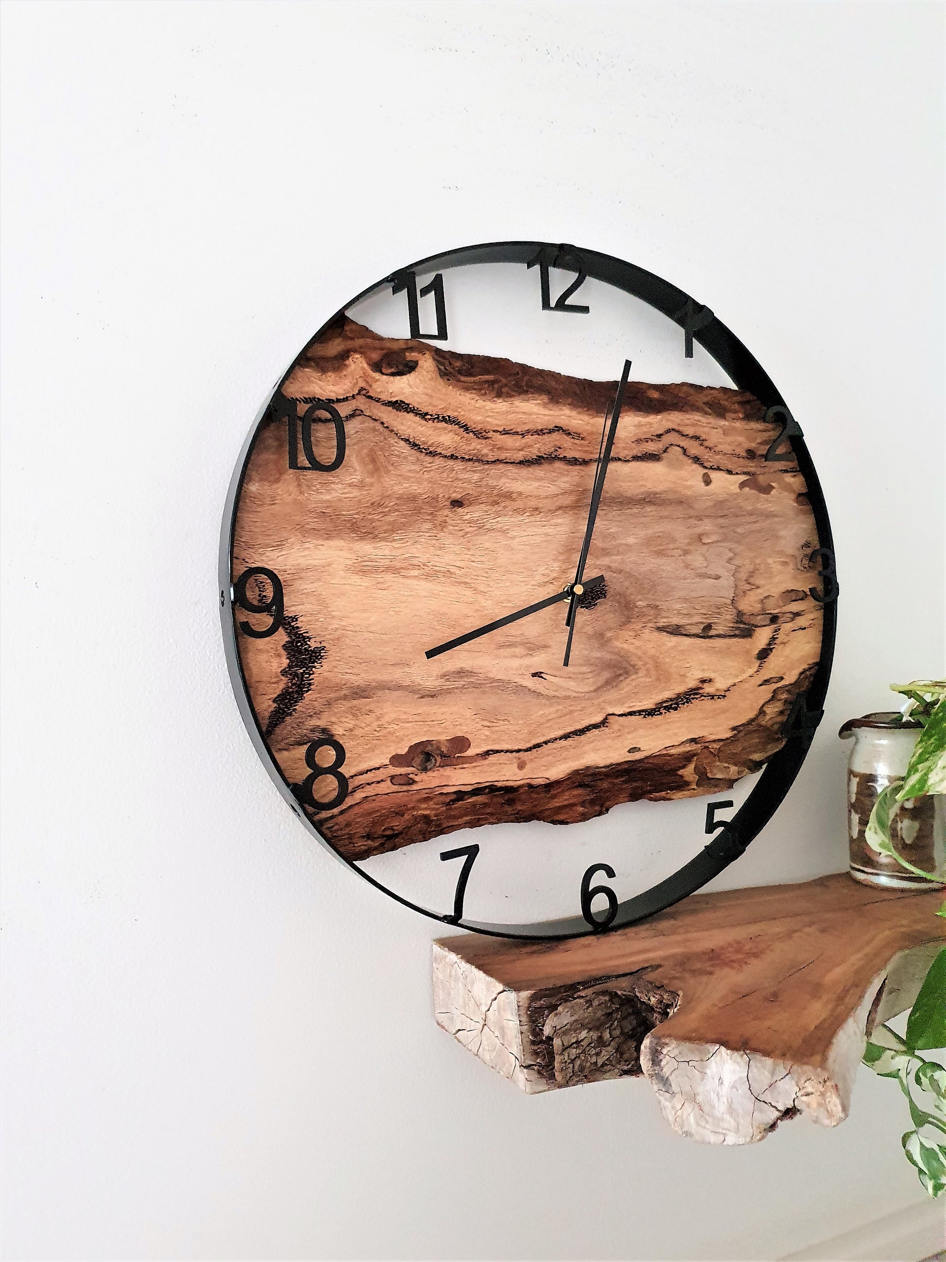 Wooden wall clock with natural finish on a white wall