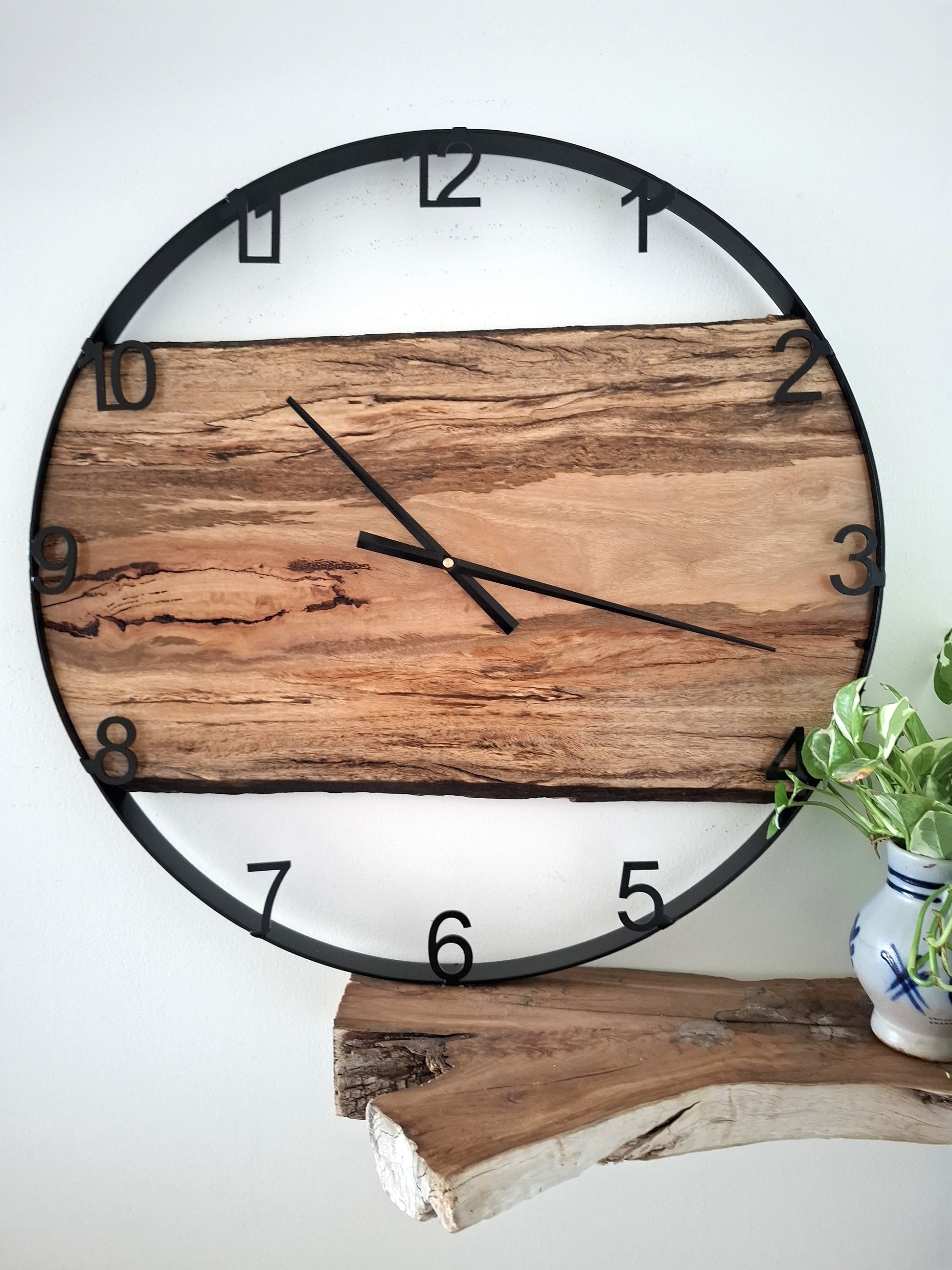 Wooden wall clock with black frame on a white background