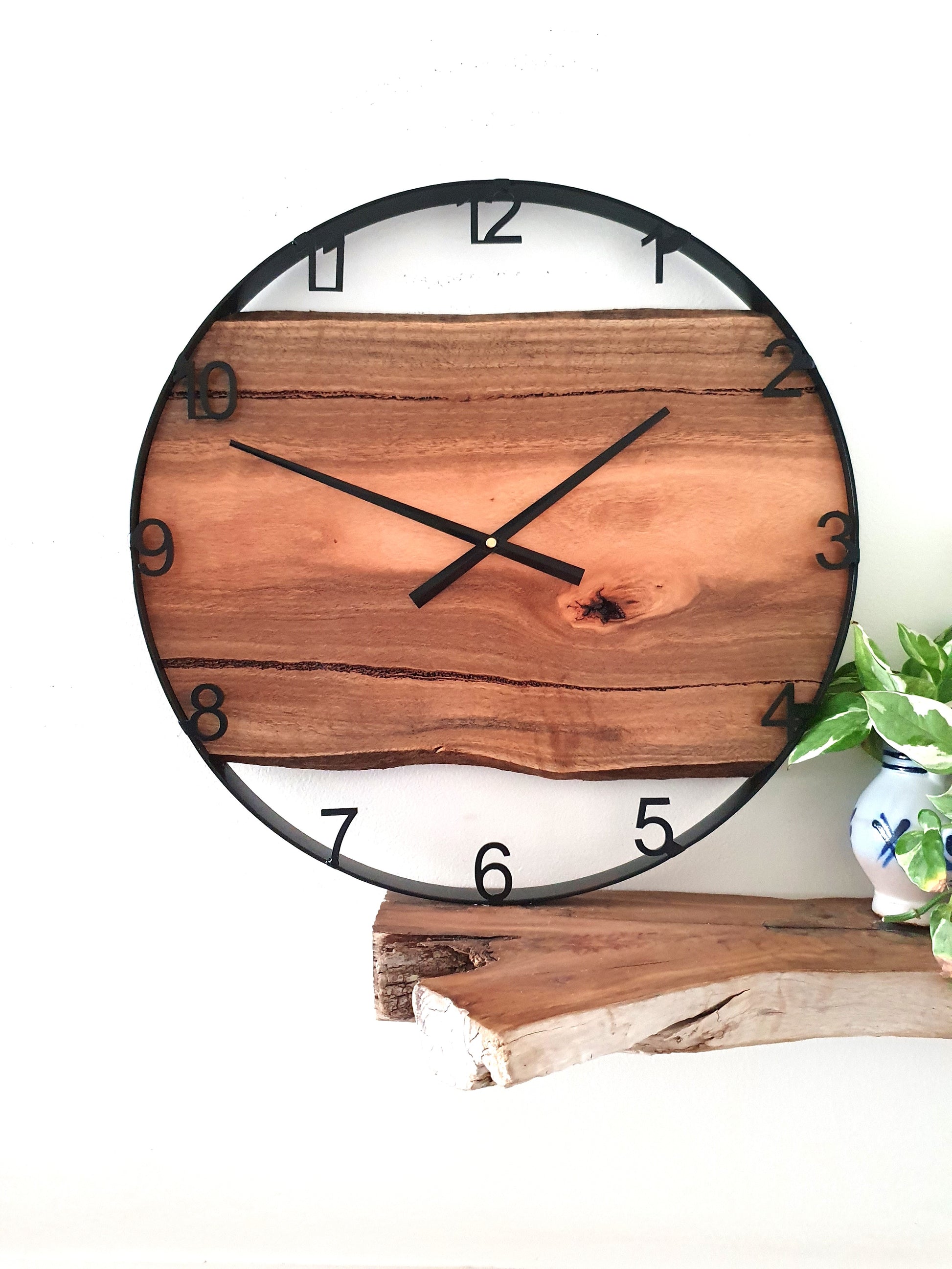 Wooden wall clock with black frame on a white background