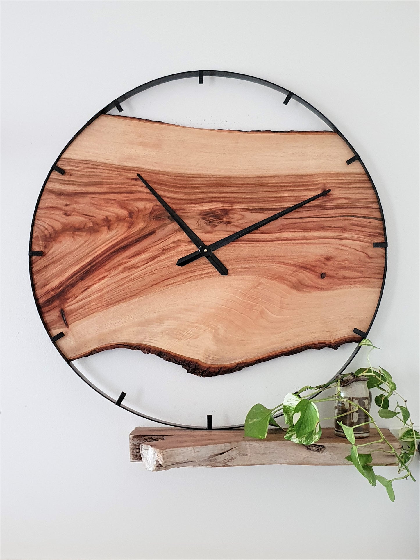 Wooden wall clock with natural finish on a white background