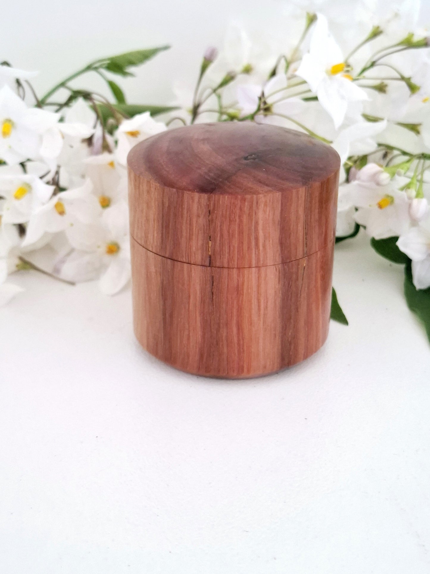 Wooden ring box with a lid on a white background with white flowersng box