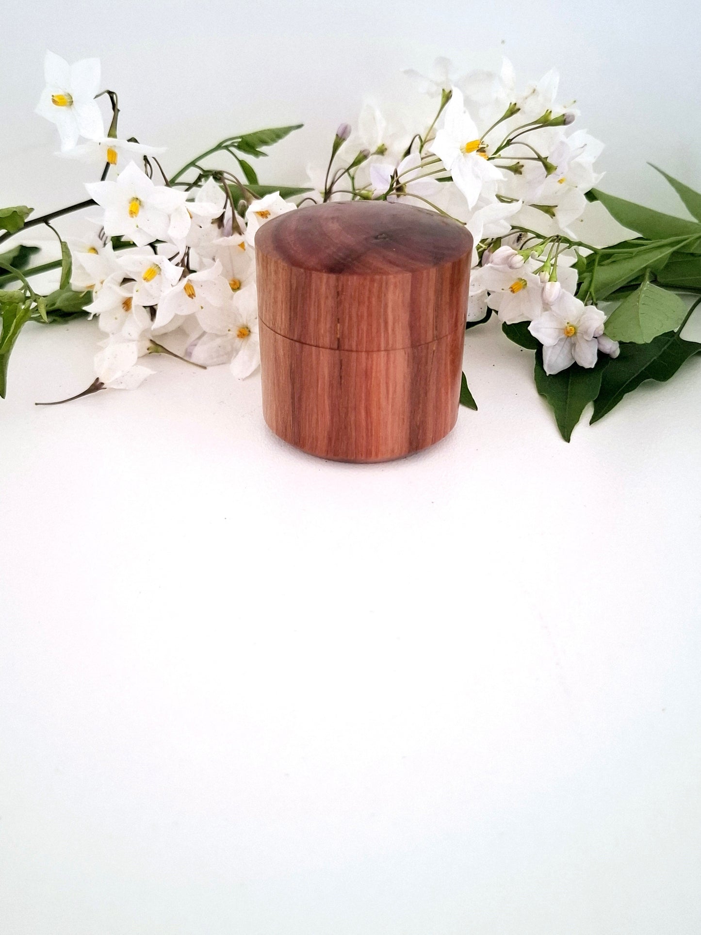 Wooden ring box with a lid on a white background with white flowers
