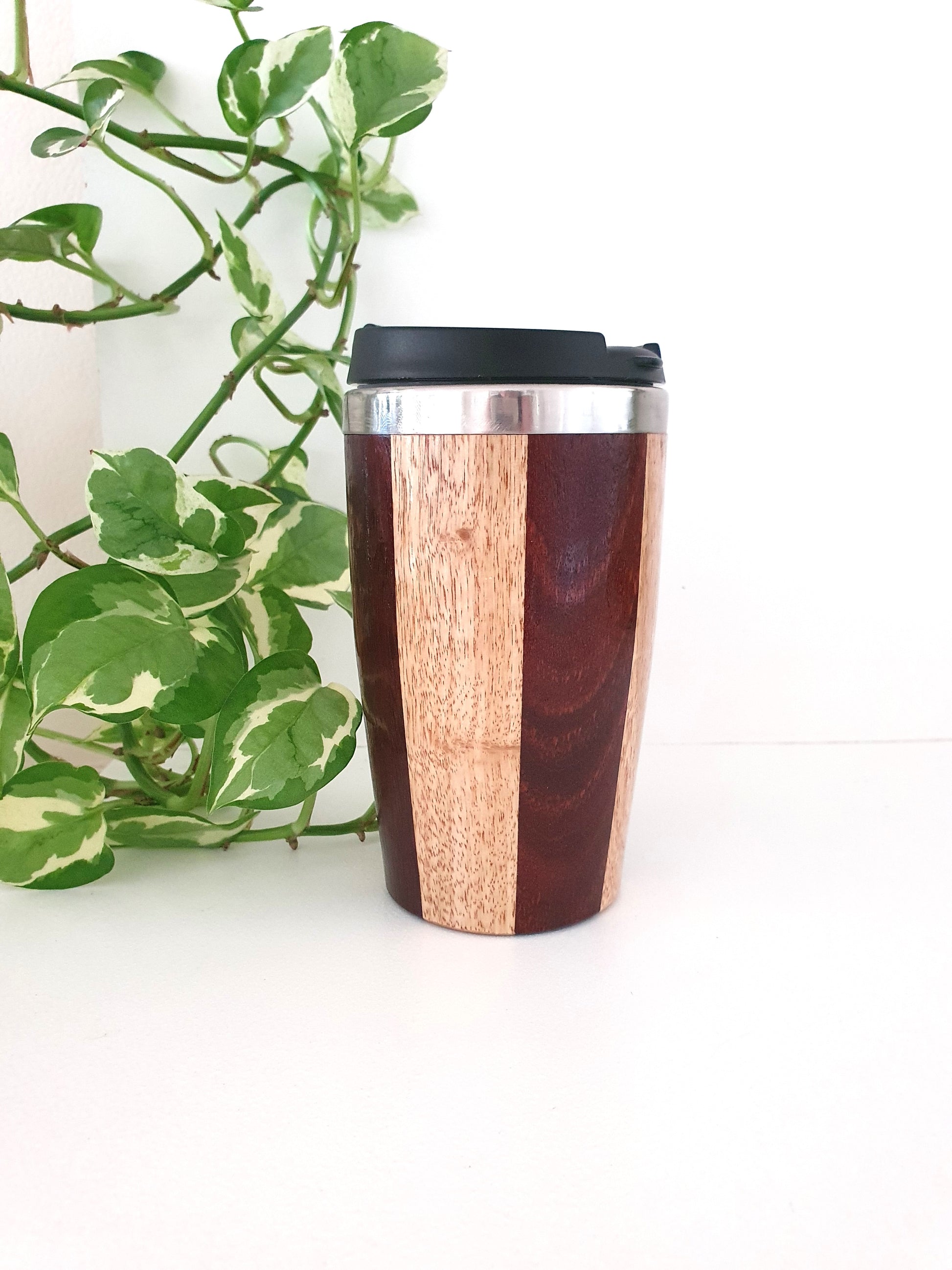 Wooden travel mug with a plant on a white background