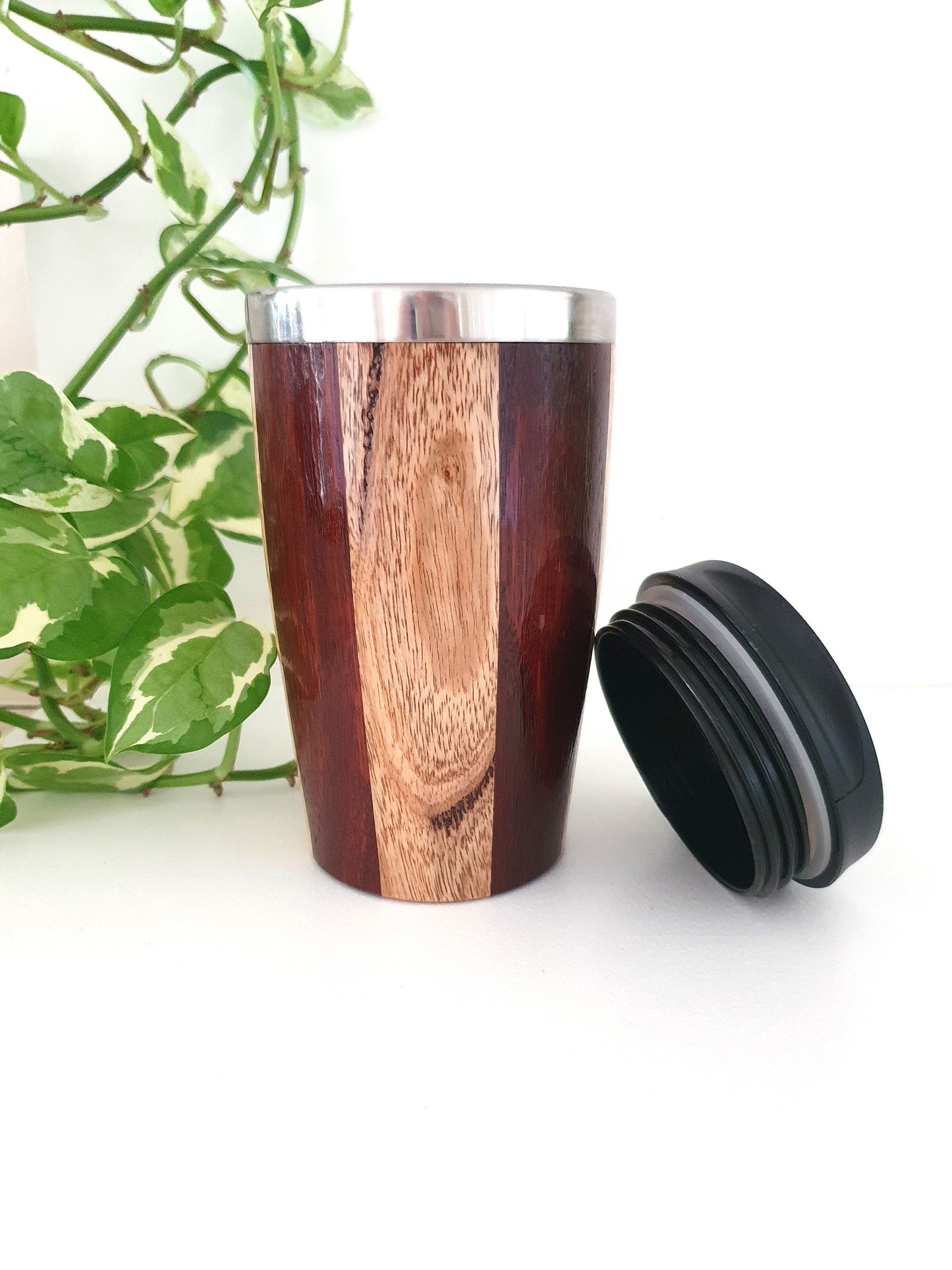 Wooden travel mug with a black lid on a white background
