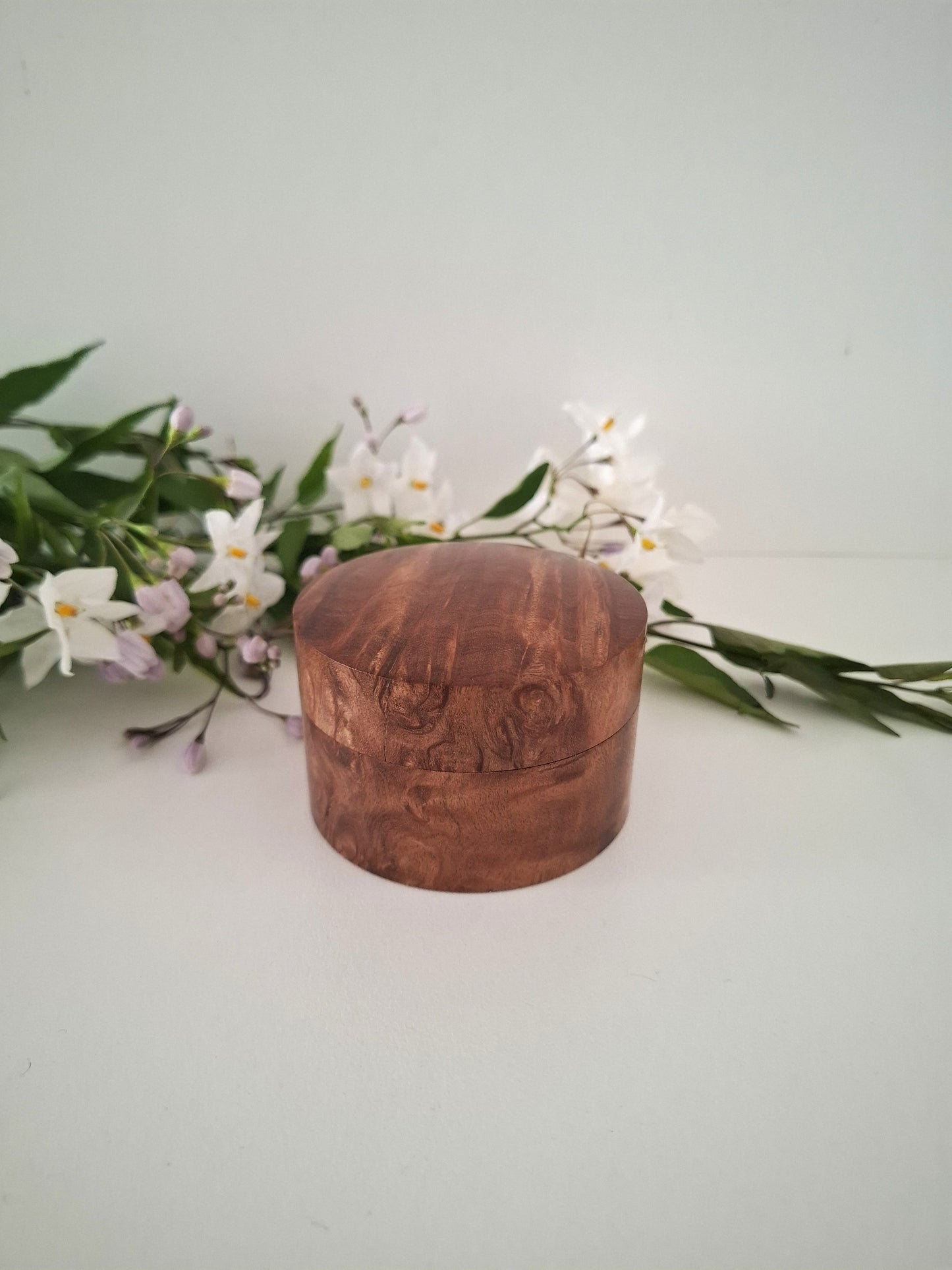 Wooden box with floral arrangement on a light background