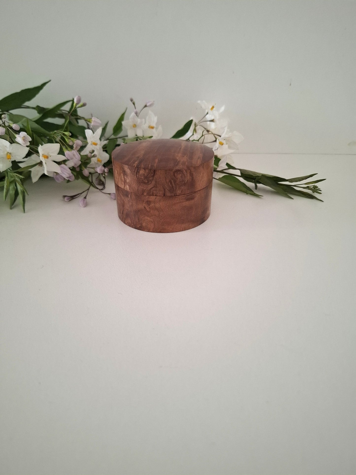Wooden box with floral arrangement on a white surface