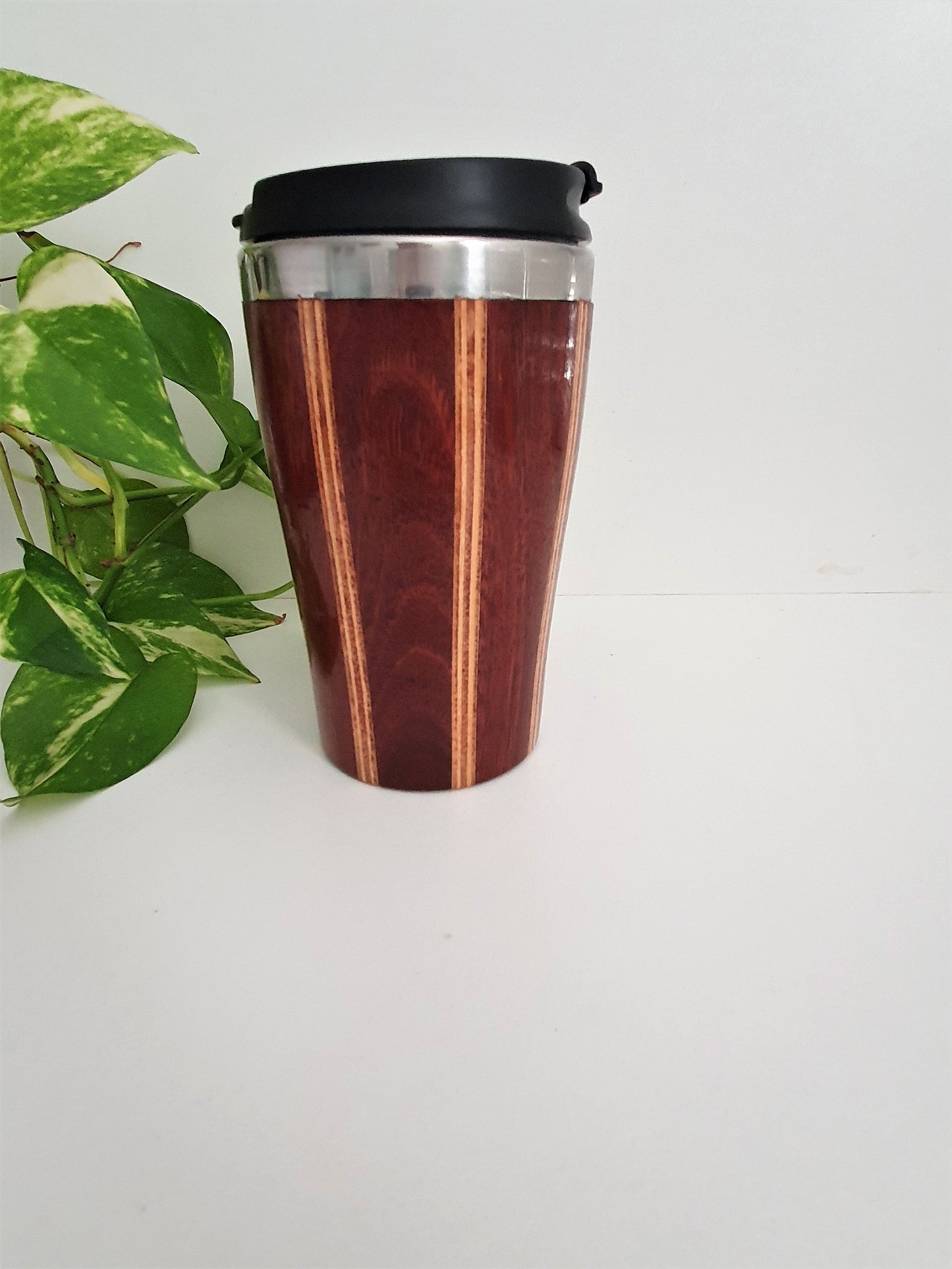Wooden travel mug with black lid on a white background