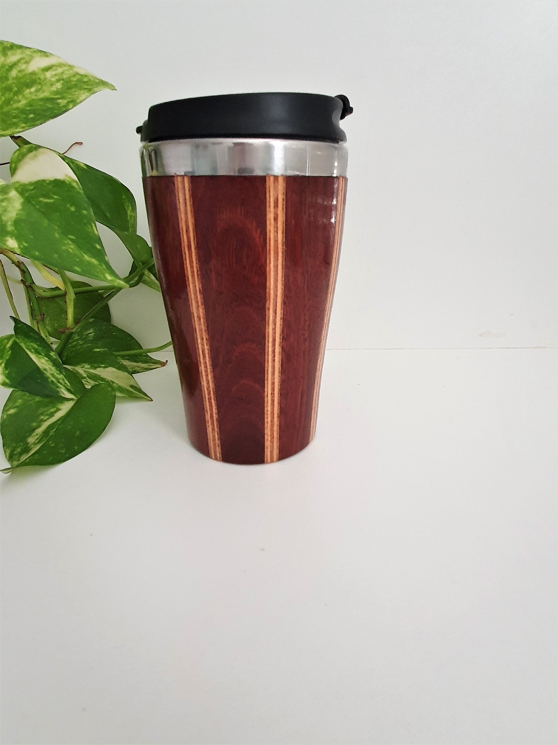 Wooden travel mug with black lid on a white background