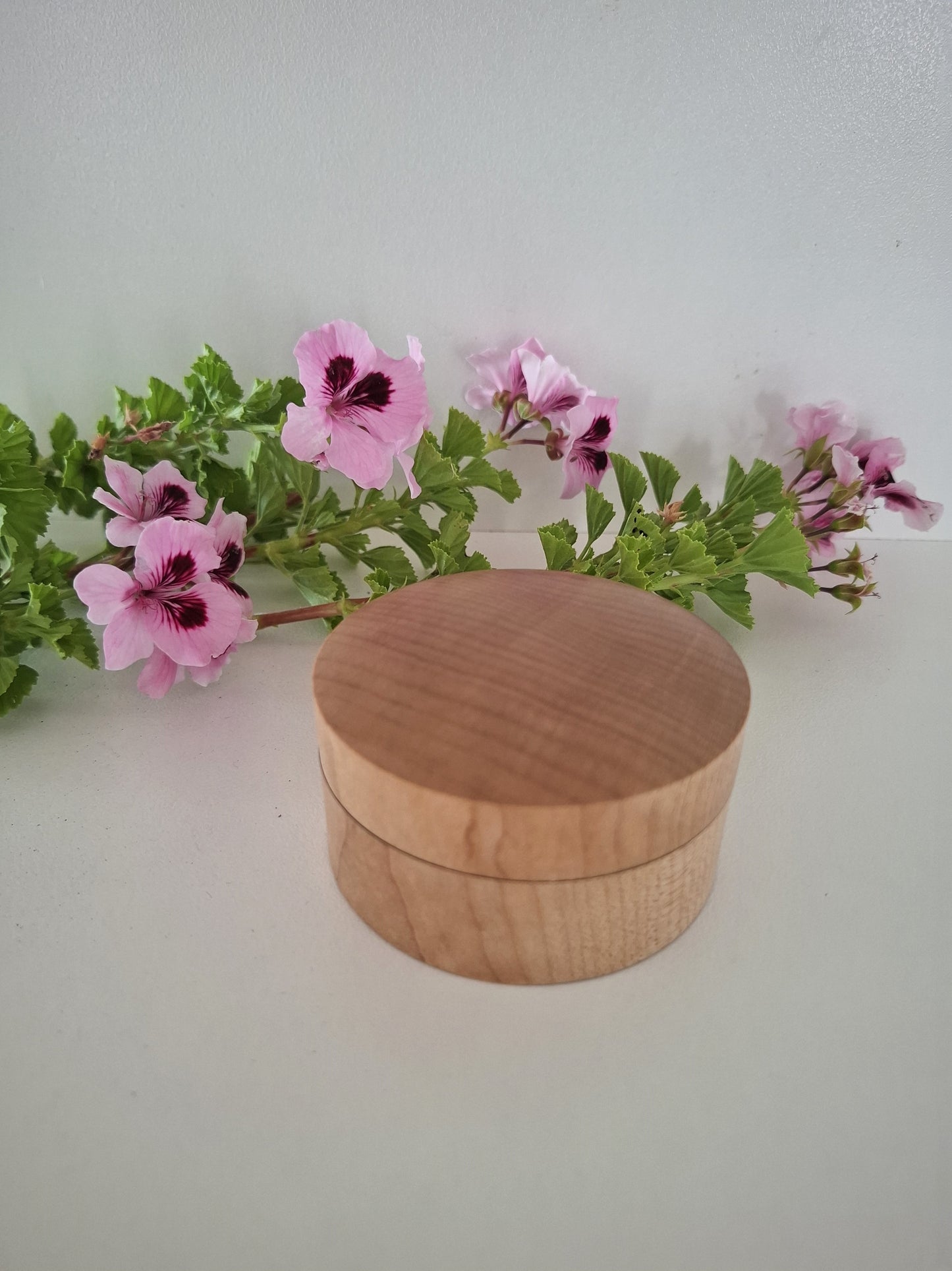 Wooden Ring Box with a lid on a white background with pink flowers and green leaves.